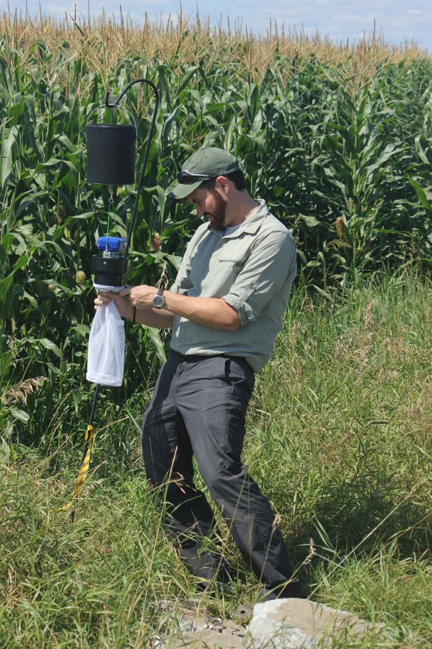 Chris in the field, checking a trap.